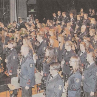 Foto des Orchesters, Dirigent Andreas Reuber vorne stehend.